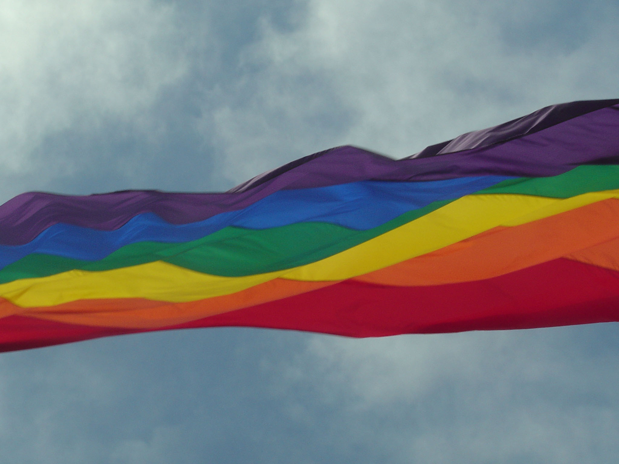 Над портом реяли разноцветные флаги. Флаг радуги. Разноцветный флаг.